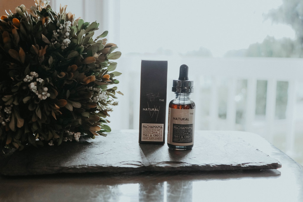 CBD tincture bottle beside dried flowers